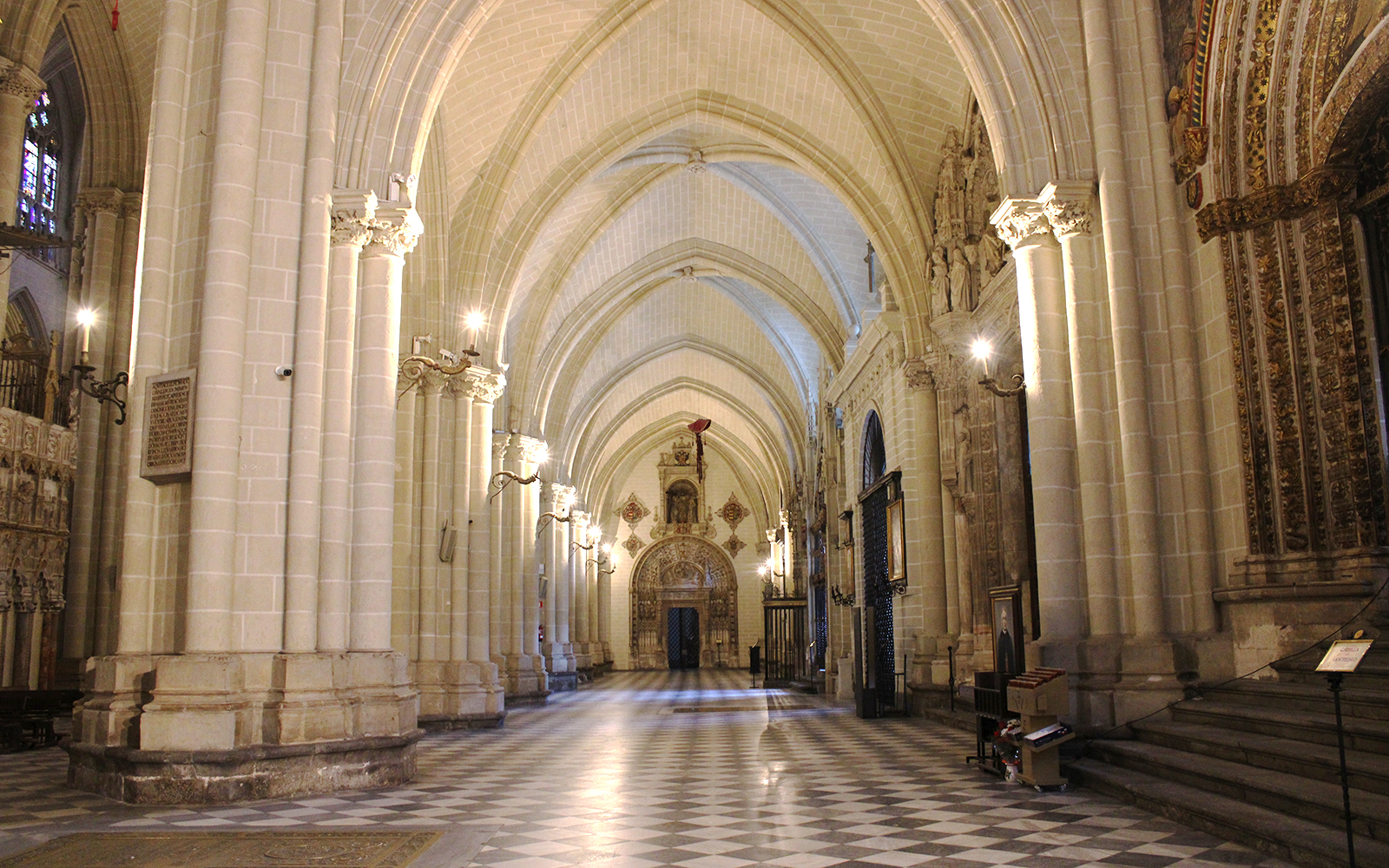 Toledo Cathedral Chapel of the New Monarchs interior with ornate ceiling and stained glass windows.