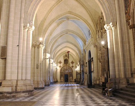 Toledo Cathedral Chapel of the New Monarchs interior with ornate ceiling and stained glass windows.