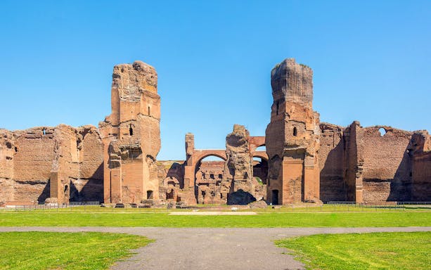 Ancient ruins of the Baths of Caracalla in Rome, showcasing towering brick structures.