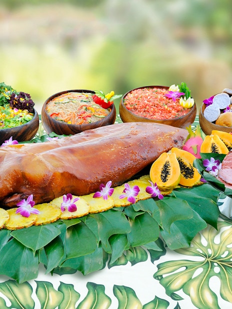 Waikiki Luau buffet with roast pig, tropical fruits, and salads at Rock-A-Hula Show.