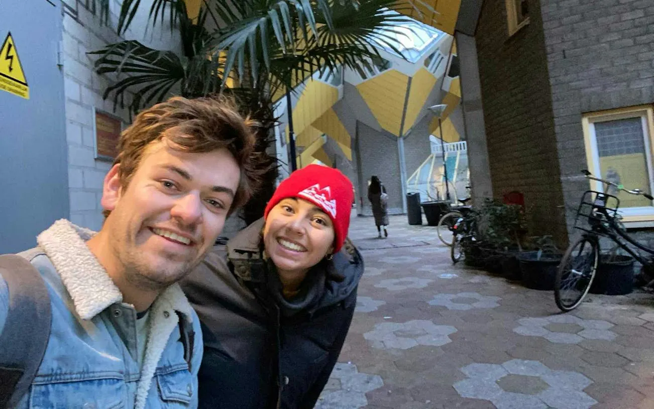 People smiling near Rotterdam's Cube Houses during a self-guided city exploration game.