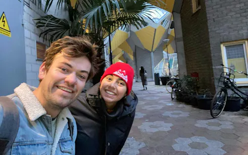People smiling near Rotterdam's Cube Houses during a self-guided city exploration game.