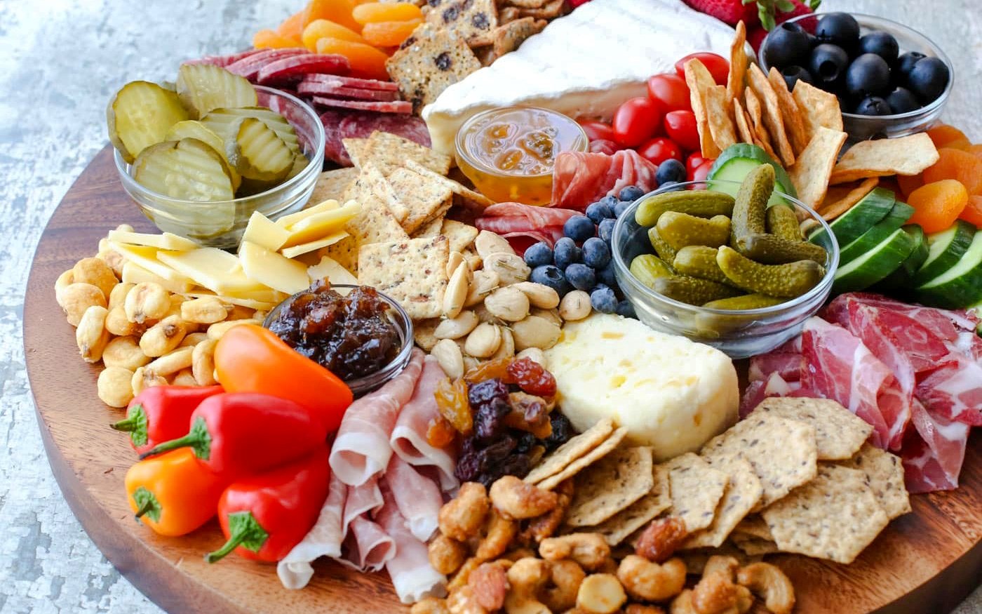 Cheese and charcuterie platter with pickles, nuts, and fruits for Scenic Wine and Cheese Harbour Cruise.