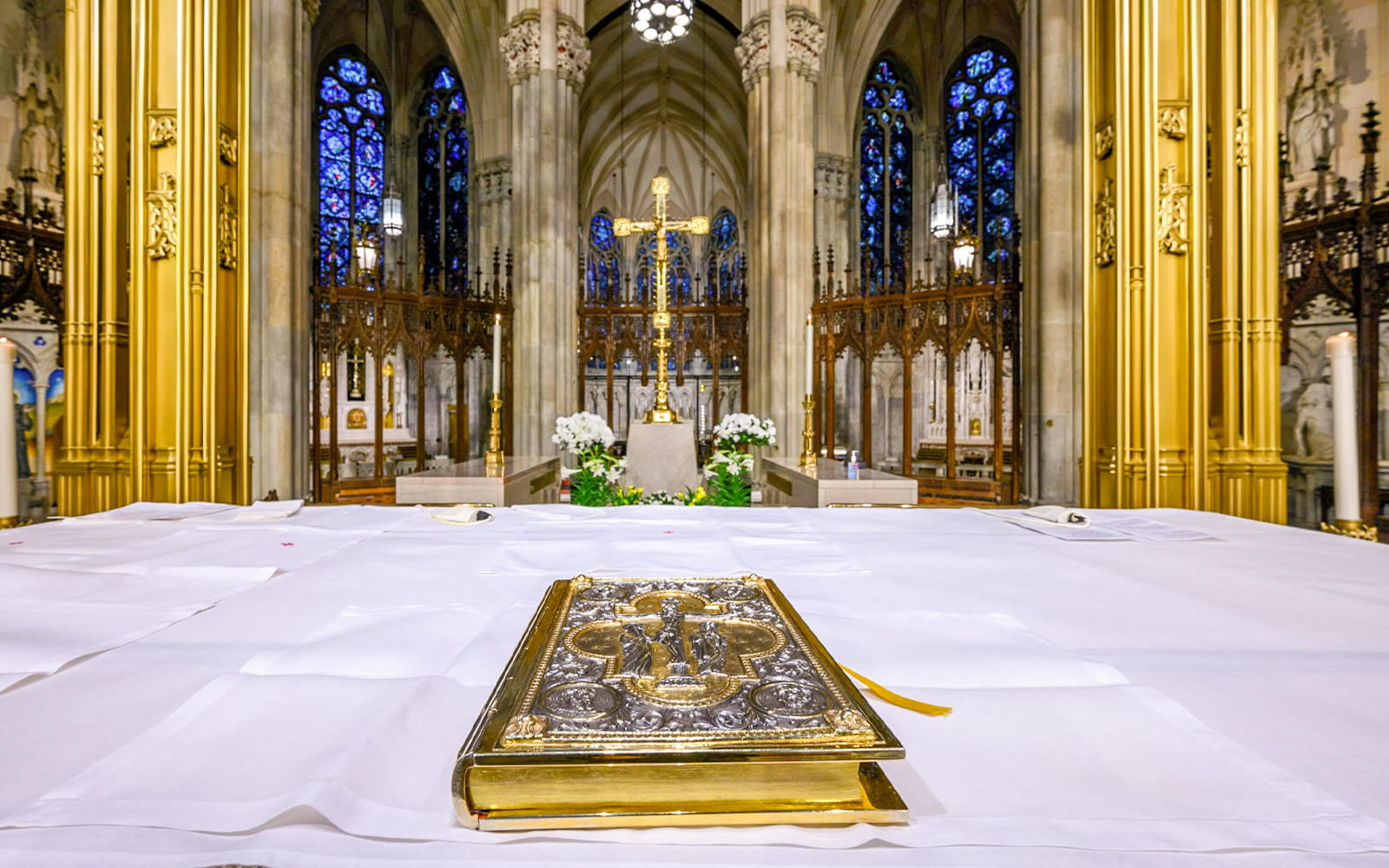Altar view inside St. Patrick's Cathedral with ornate Bible and golden cross.