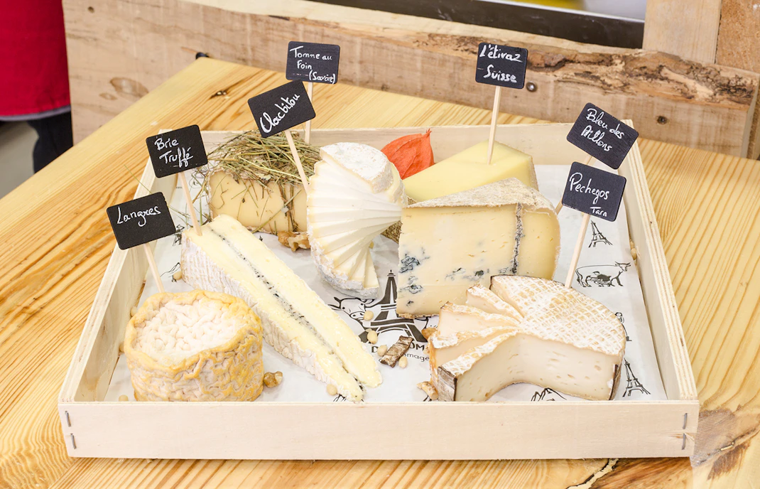 Cheese selection at Cheese Museum Paris, featuring Brie Truffé and Bleu des Causses.