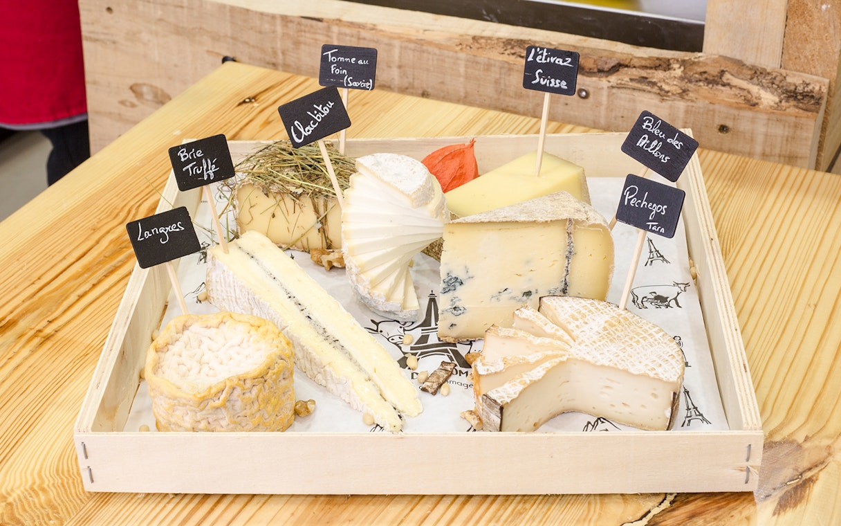 Cheese selection at Cheese Museum Paris, featuring Brie Truffé and Bleu des Causses.
