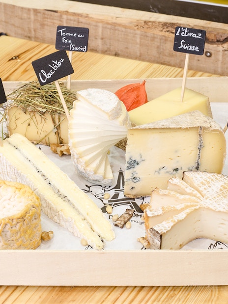 Cheese selection at Cheese Museum Paris, featuring Brie Truffé and Bleu des Causses.
