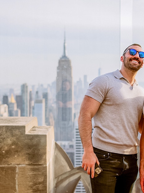Men taking a selfie at Top of the Rock, with Empire State Building in background, New York.