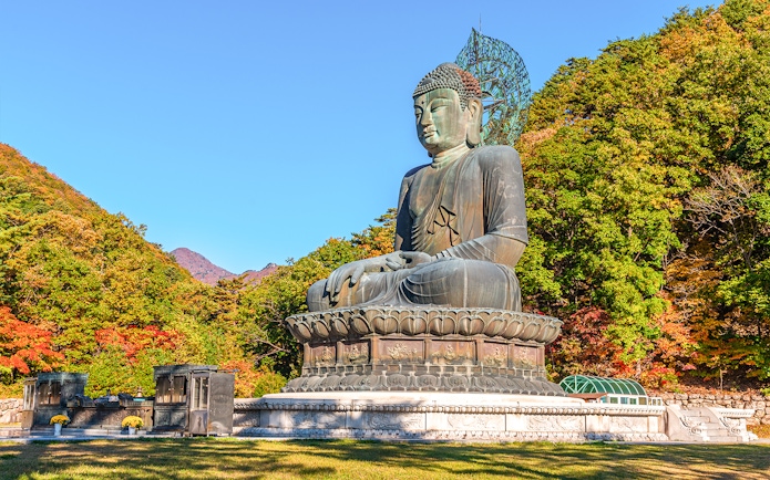 Buddha statue surrounded by autumn trees at Seoraksan National Park, Republic of Korea.