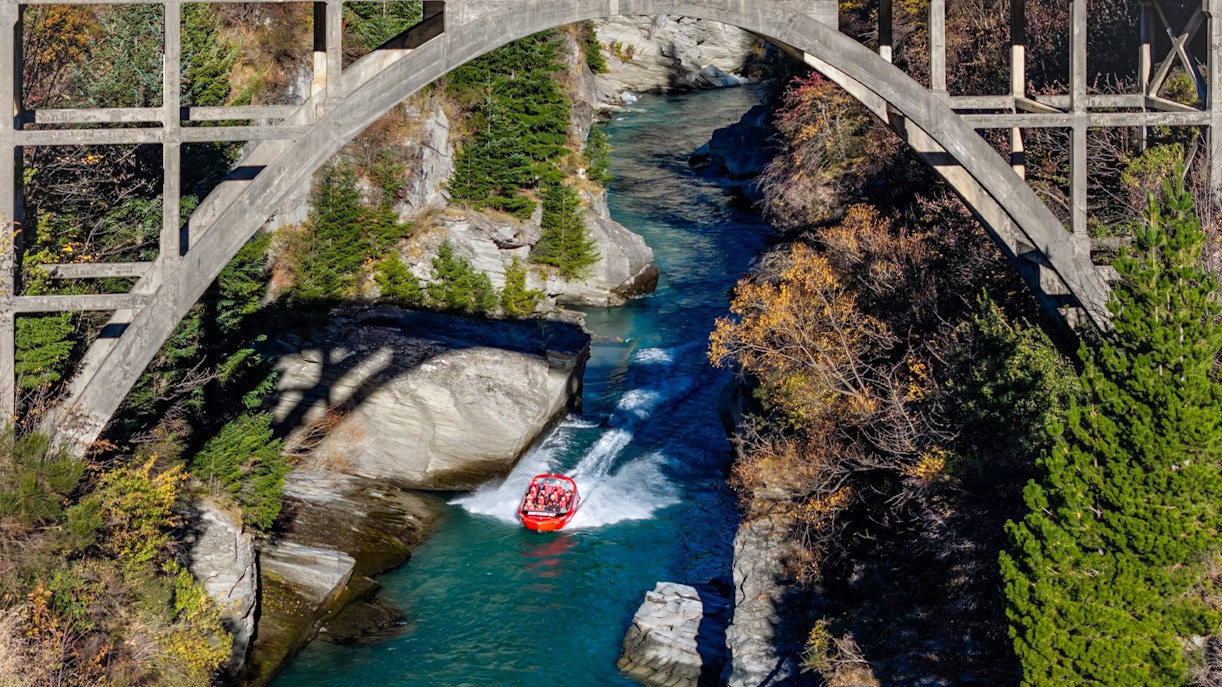 Aerial view of tourists on Shotover Jet navigating a narrow canyon in New Zealand.