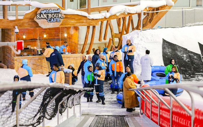 Visitors in winter gear at Snow Dunes Theme Park near Sanbouk Cafe.