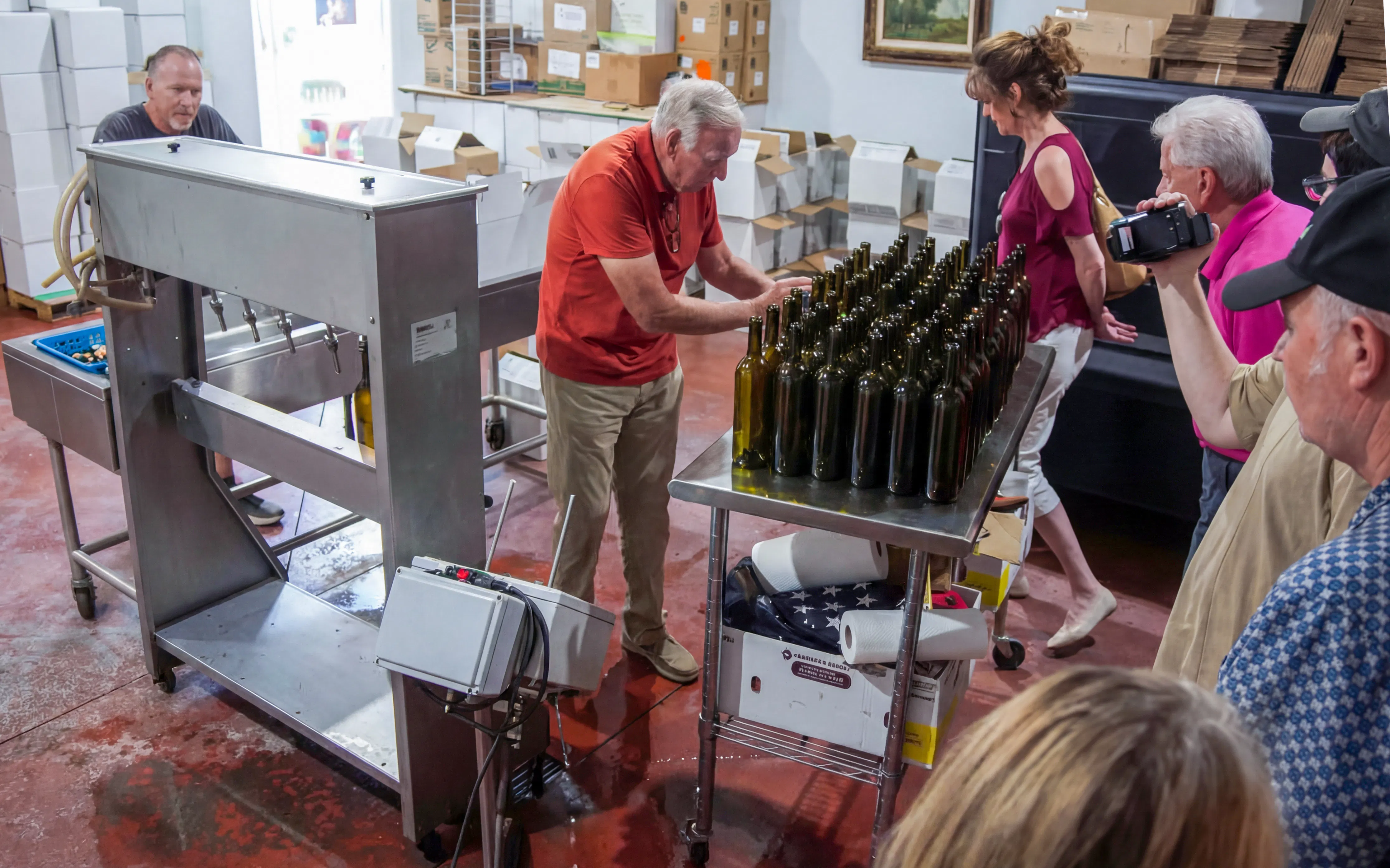 Winery tour in Nevada with visitors observing bottling process.