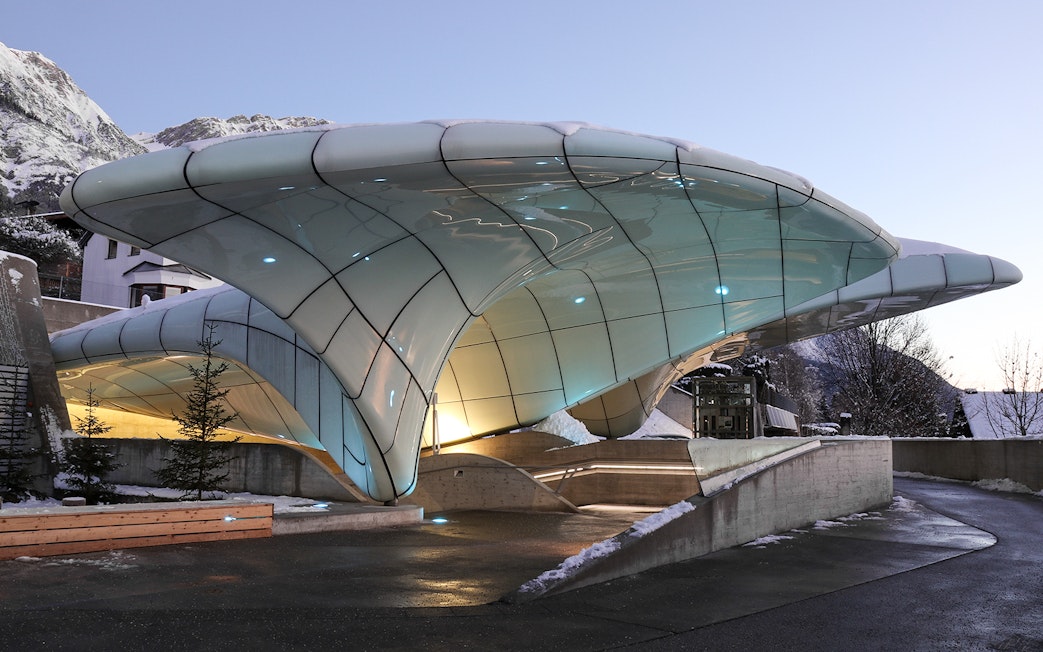 Nordkettenbahn station with modern architecture in Innsbruck, Austria, against a mountain backdrop.