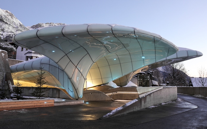 Nordkettenbahn station with modern architecture in Innsbruck, Austria, against a mountain backdrop.