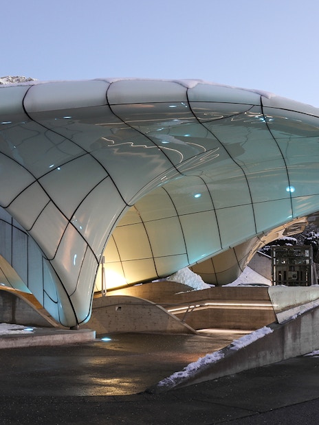 Nordkettenbahn station with modern architecture in Innsbruck, Austria, against a mountain backdrop.