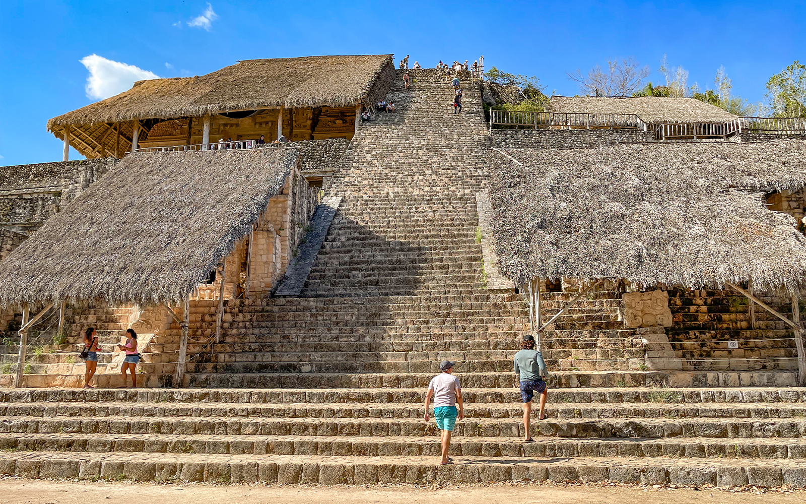 Tourists climbing the steps of the Ek Balam pyramid in Yucatán, Mexico.