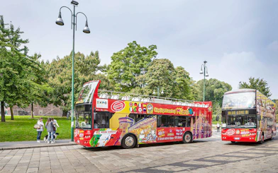 City Sightseeing Milan hop-on hop-off buses at a passenger stop.