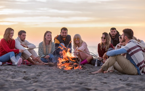 Group enjoying a beach bonfire during Albufeira sunset cruise with barbeque dinner.