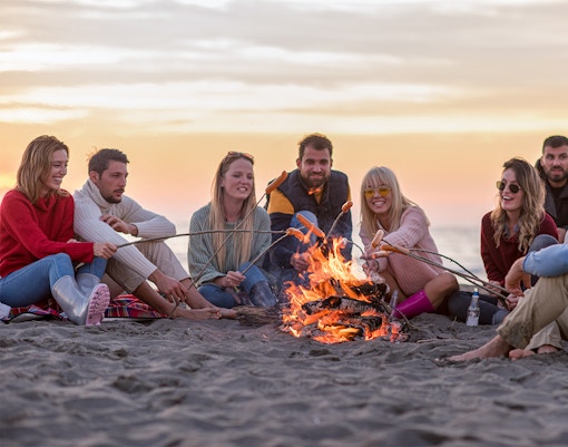 Group enjoying a beach bonfire during Albufeira sunset cruise with barbeque dinner.