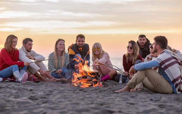Group enjoying a beach bonfire during Albufeira sunset cruise with barbeque dinner.