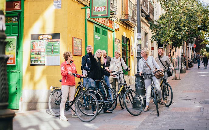 Group of cyclists on a street in Madrid during a highlights bike tour.
