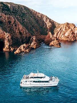 Cruise boat near rocky coastline of Phillip Island, Australia.