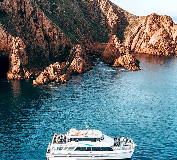 Cruise boat near rocky coastline of Phillip Island, Australia.