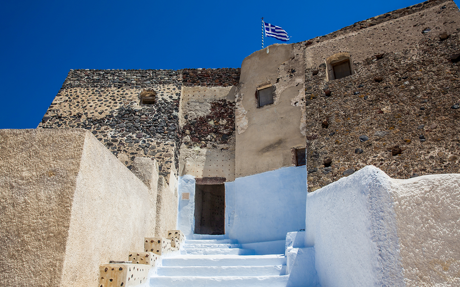 Stone walls and steps leading to the Ruins of the Castle of Akrotiri, Greece.
