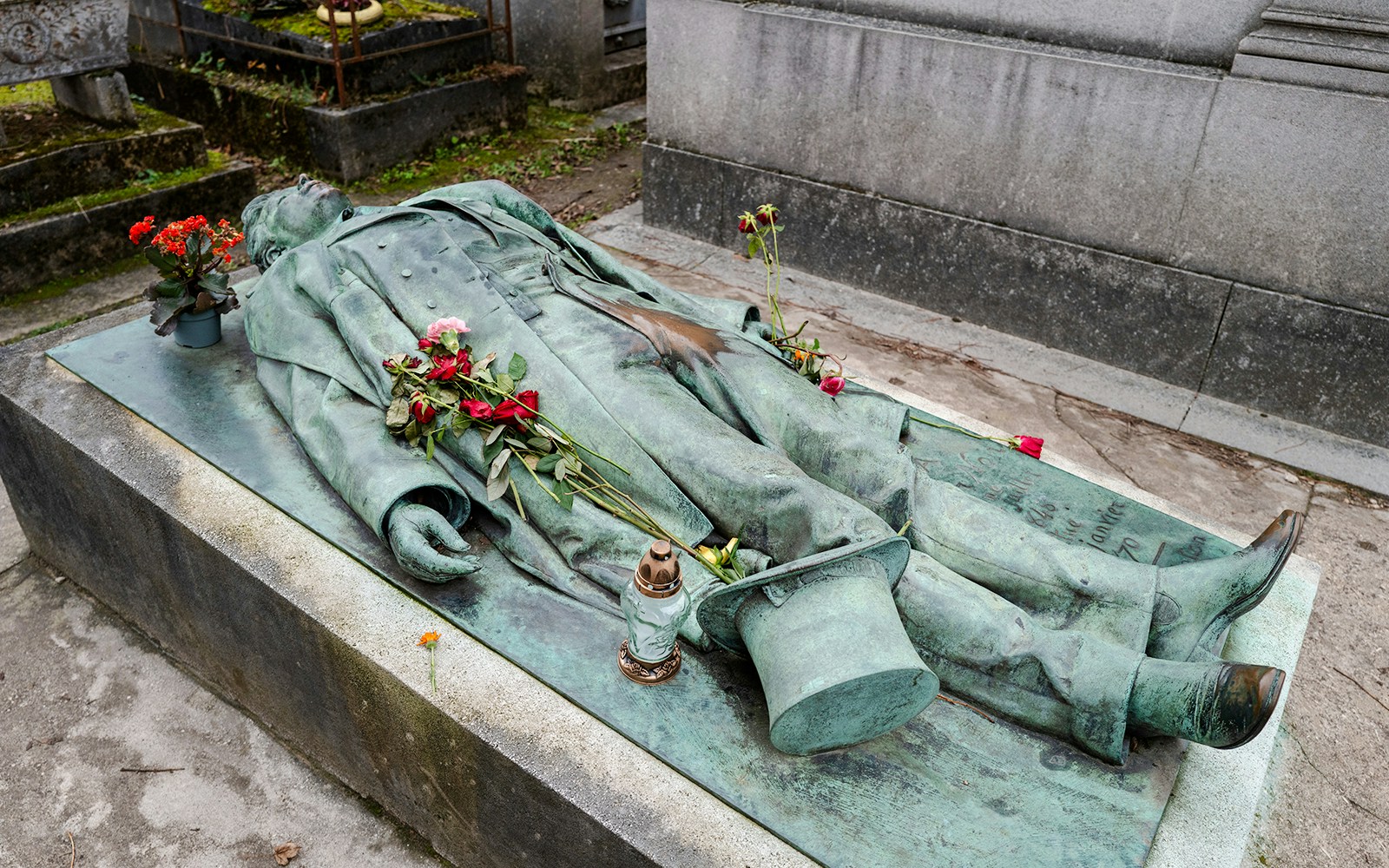 Victor Noir grave statue with flowers at Père Lachaise Cemetery, Paris.