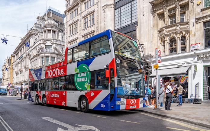 Tootbus London hop-on hop-off bus at Coventry Street with tourists nearby.