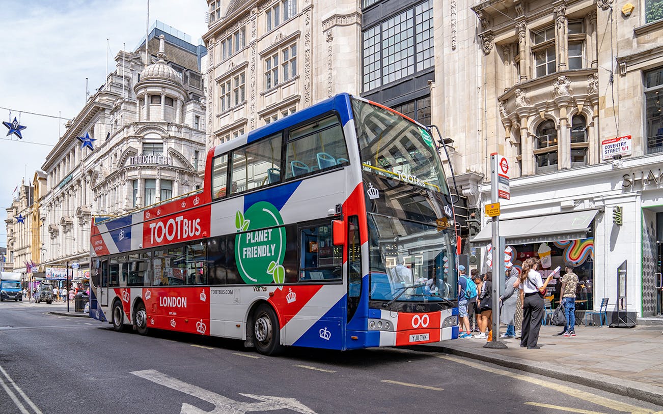Tootbus London hop-on hop-off bus at Coventry Street with tourists nearby.
