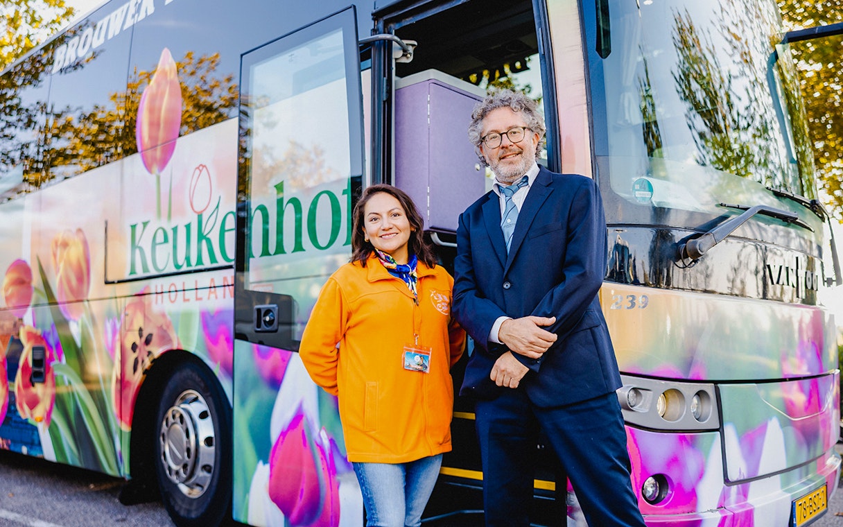 Driver and guide standing by a tour bus at Zaanse Schans, Netherlands.