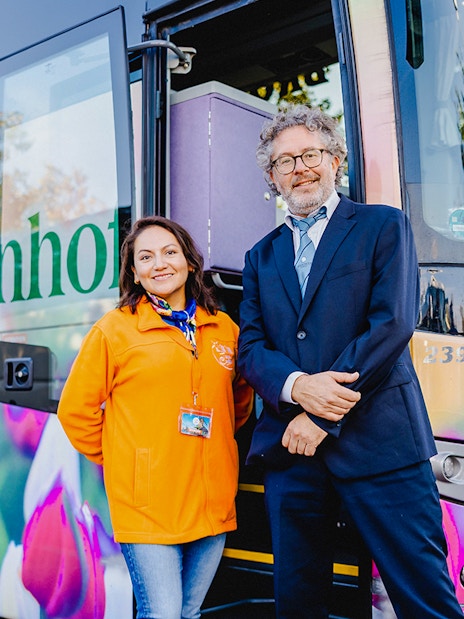 Driver and guide standing by a tour bus at Zaanse Schans, Netherlands.