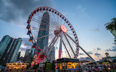 Hong Kong Observation Wheel at sunset with city skyline in the background.