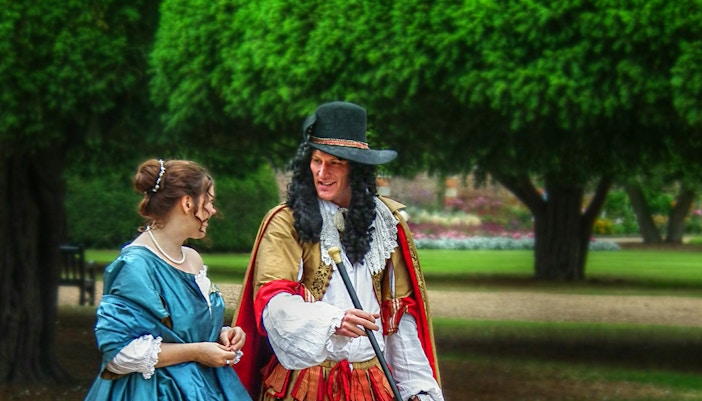 a man in a costume talking to a woman in a dress