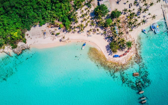 Aerial view of Saona Island, Punta Cana, showing beach, boats, and tropical vegetation.