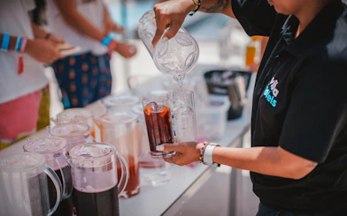 Pouring drinks at Cruise Crush Boat Party with pitchers and glasses on a table.