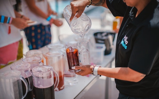 Pouring drinks at Cruise Crush Boat Party with pitchers and glasses on a table.