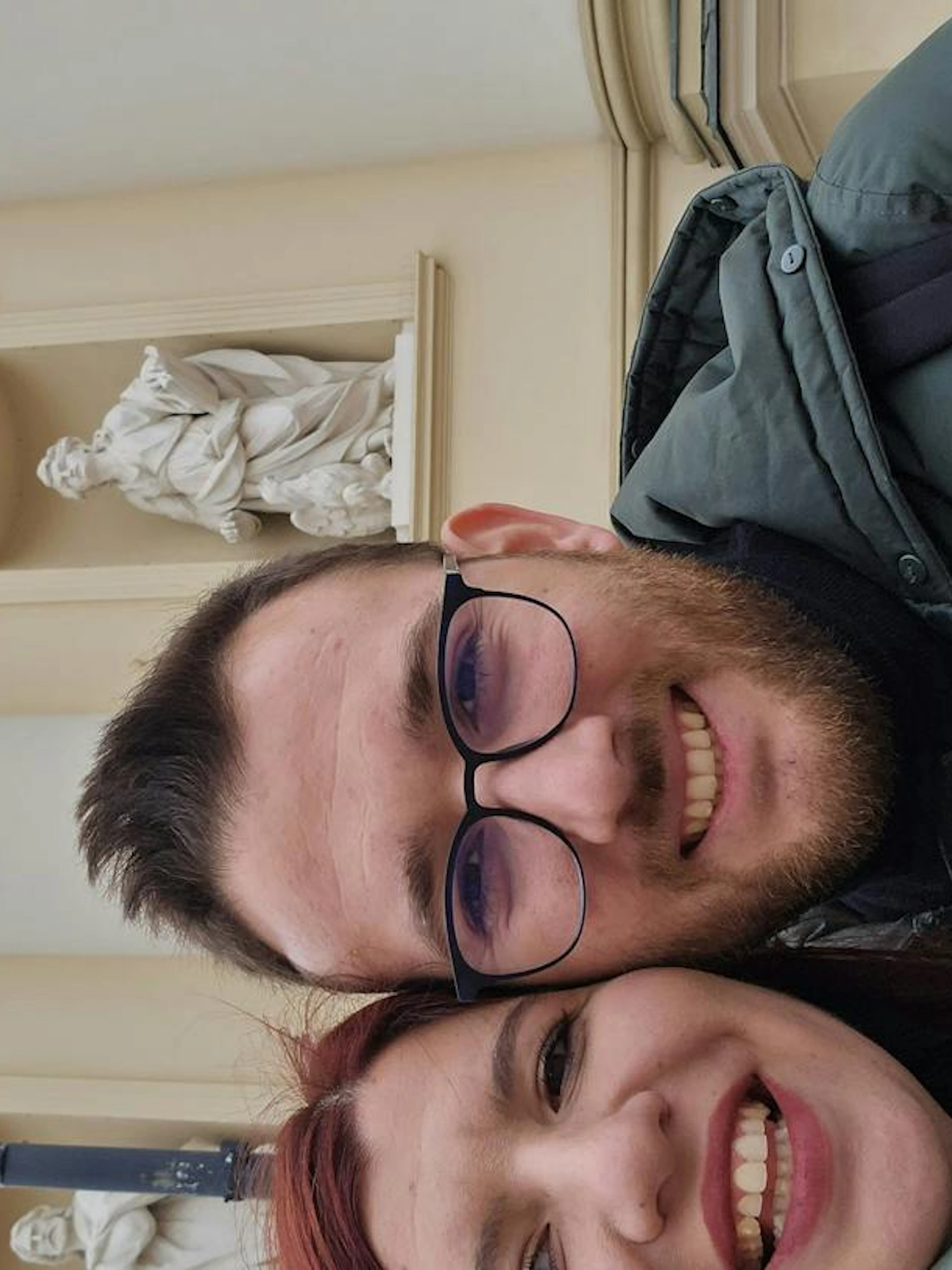 Couple smiling in front of a historic building in Warsaw during a self-guided city exploration game.