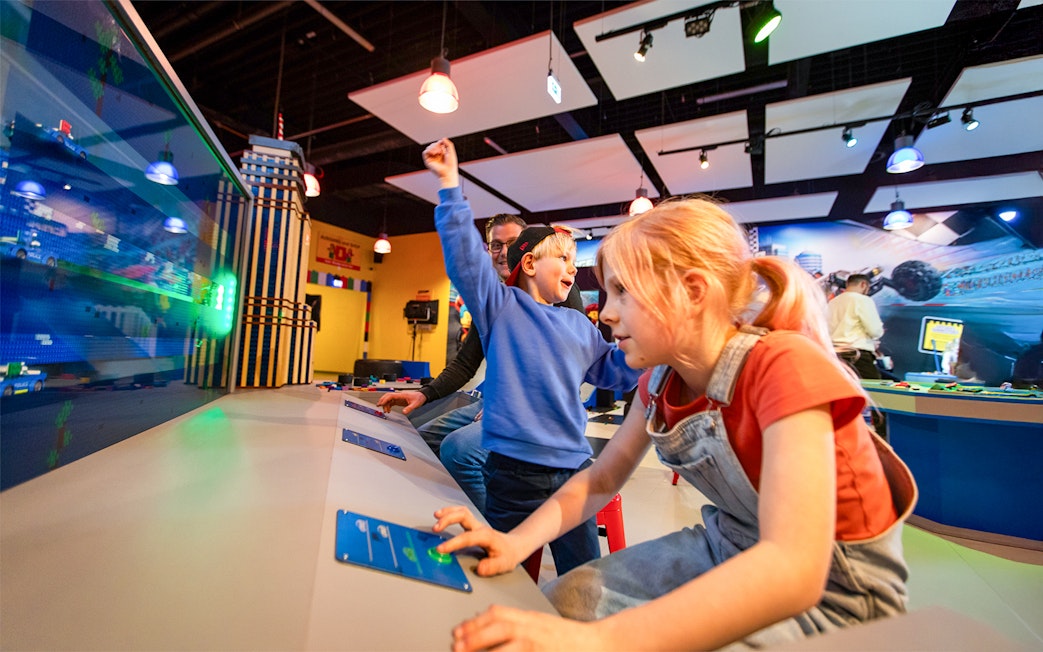 Kids interacting with buttons to reveal Lego surprises at LEGOLAND Discovery Centre Oberhausen.