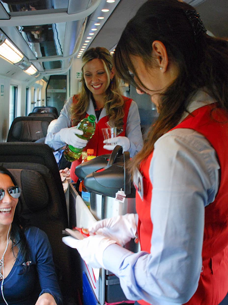 Traveller receiving refreshments from staff on an Interrail train journey.