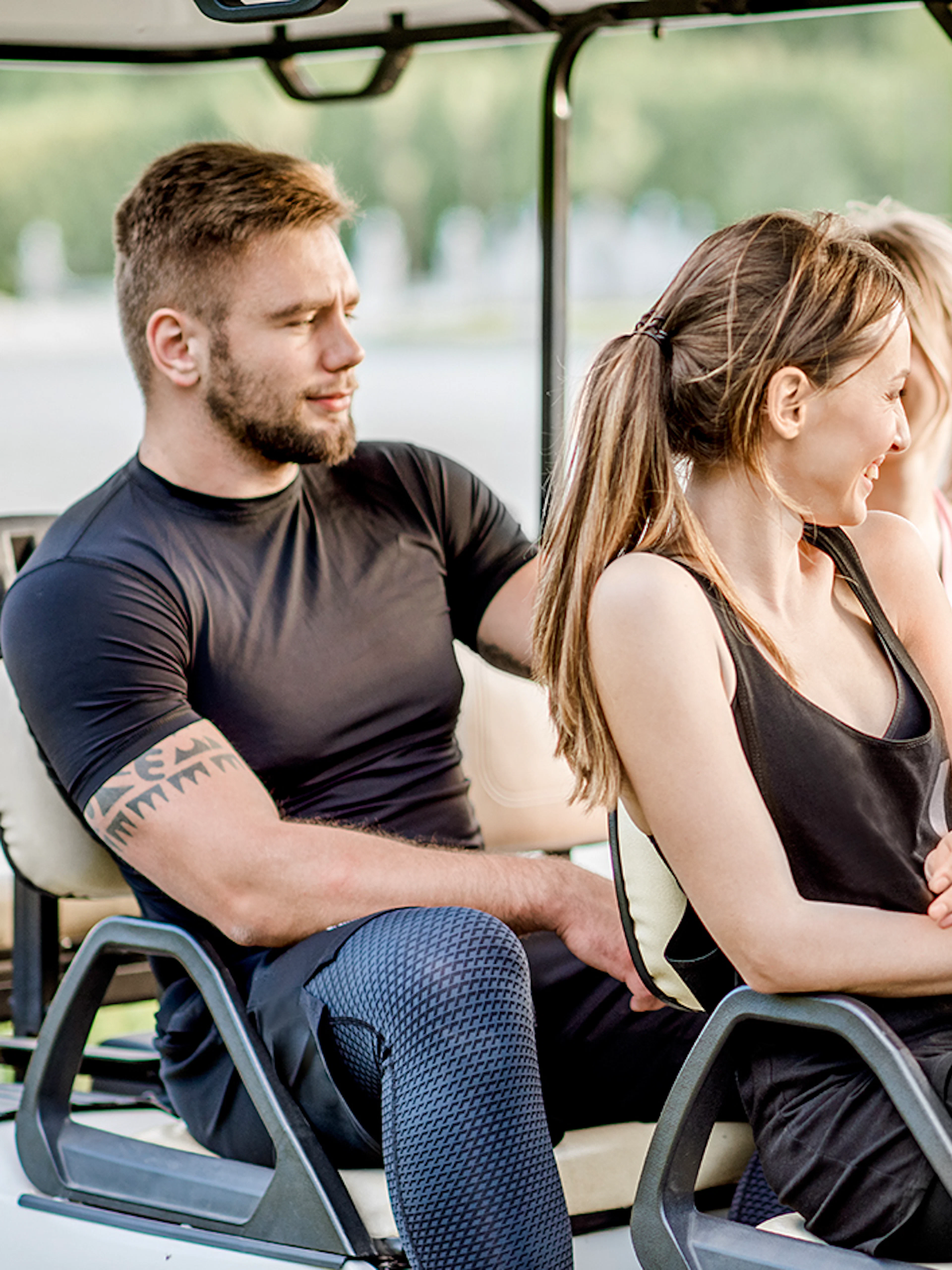 Friends enjoying a ride in a golf cart.
