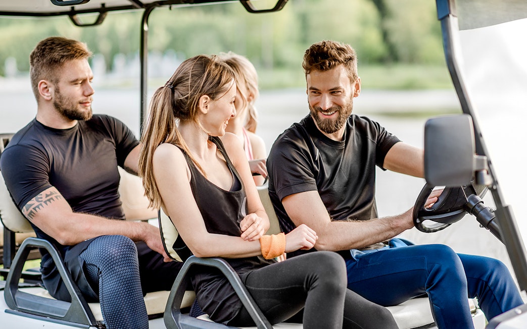 Friends enjoying a ride in a golf cart.