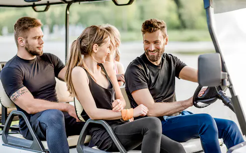 Friends enjoying a ride in a golf cart.