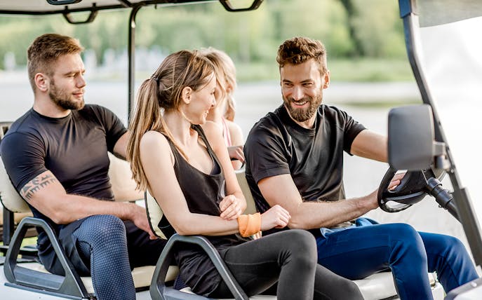 Friends enjoying a ride in a golf cart.