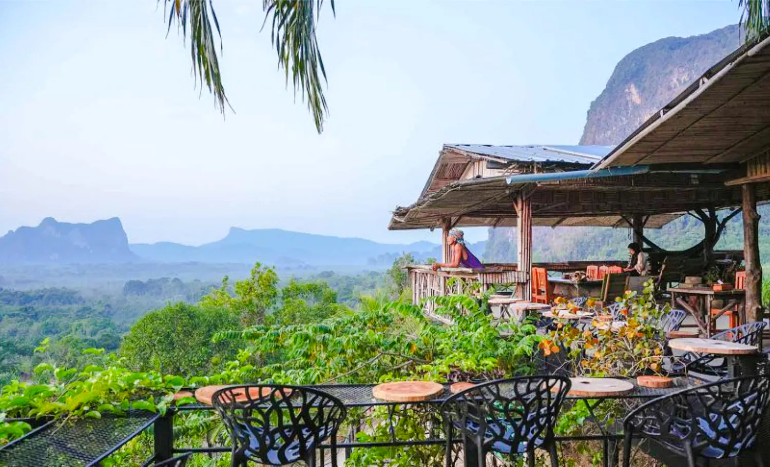 Hilltop view from Khuan Nom Sao viewpoint with lush greenery and distant mountains, Krabi.