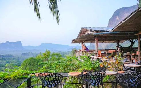 Hilltop view from Khuan Nom Sao viewpoint with lush greenery and distant mountains, Krabi.