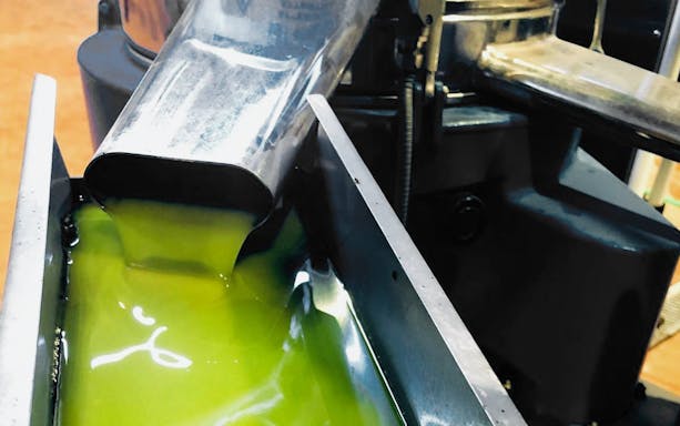 Olive oil flowing from a machine at Navarro García outlet in Granada.
