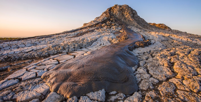 Active mud volcano in Gobustan desert, Azerbaijan with cracked earth and flowing mud.