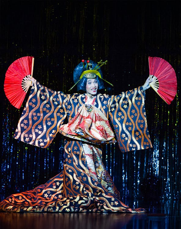 Performer in traditional costume with fans at Calypso Cabaret Show, Bangkok.